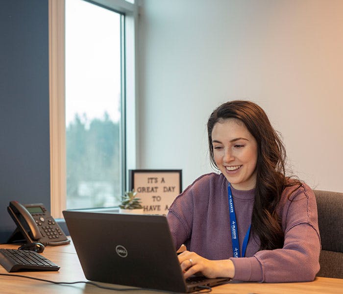 Female employee happily working at computer