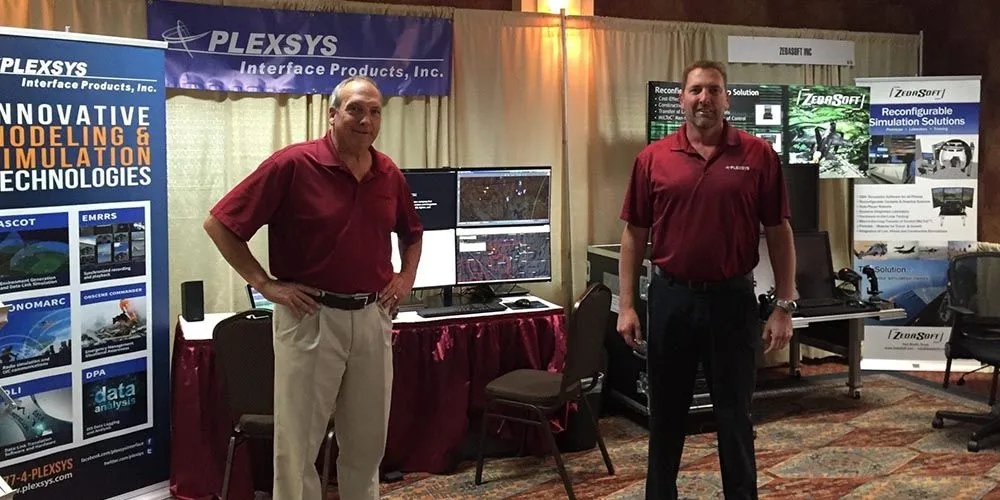 PLEXSYS Employees standing at the PLEXSYS Tradeshow booth